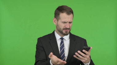 İşadamı Chroma Key karşı telefonunu kullanırken Hayal kırıklığına olsun