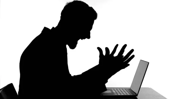 A silhueta do homem irritado trabalhando no laptop e ficar estressado — Fotografia de Stock