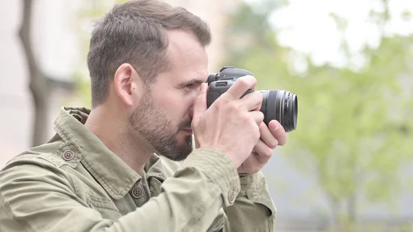 O homem bonito Clicando fotos ao ar livre na câmera — Fotografia de Stock