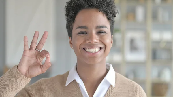 Das Porträt eines fröhlichen afrikanischen Mädchens, das ein gutes Zeichen zeigt — Stockfoto