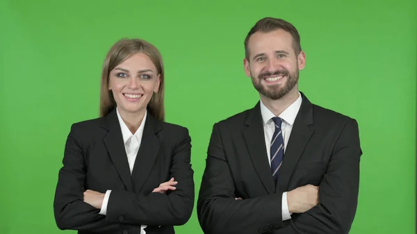 De jonge professionele man en vrouw staan met armen gekruist tegen Chroma Key — Stockfoto