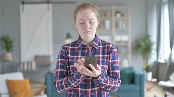 Die junge Frau im Stehen und mit dem Smartphone — Stockfoto