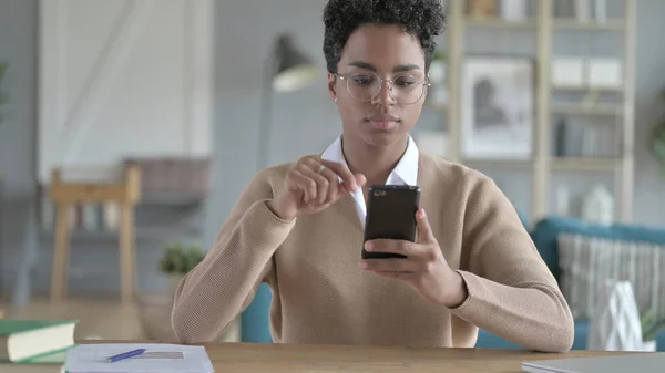 A jovem menina africana usando seu telefone inteligente — Fotografia de Stock