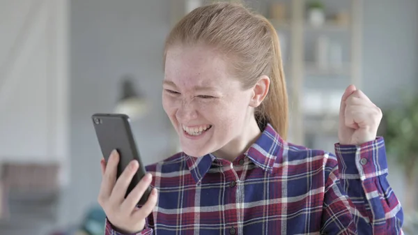 Молодая женщина, использующая телефон и испытывающая волнение — стоковое фото