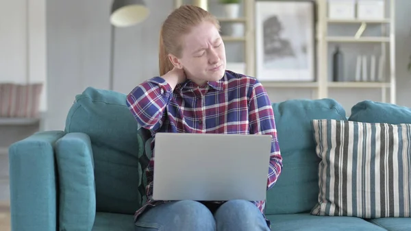 Молодая женщина, работающая над ноутбуком и страдающая от боли в шее — стоковое фото