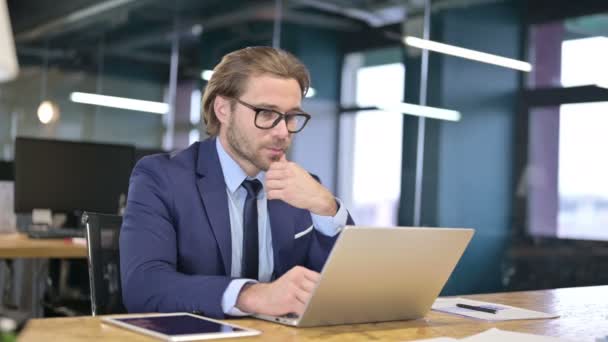 Pensamiento pensativo del hombre de negocios y trabajo en el ordenador portátil — Vídeos de Stock