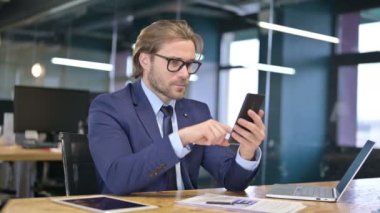 İş yerinde Smartphone kullanan İşadamı