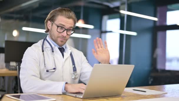 Доктор разговаривает с пациентом через видео чат на ноутбуке — стоковое видео