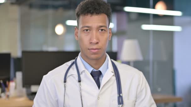 Retrato del joven doctor mirando a la cámara en la oficina — Vídeos de Stock