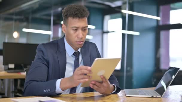 Трудолюбивый молодой бизнесмен с помощью планшета в офисе — стоковое видео