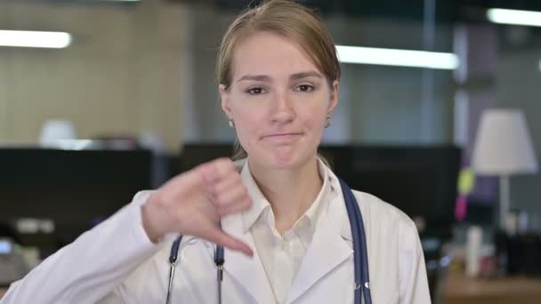 Портрет разочарованной молодой женщины-врача, делающей большой палец вниз — стоковое видео