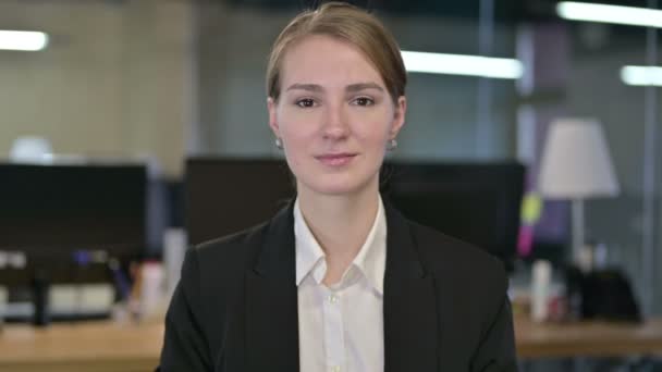 Portret van jonge zakenvrouw kijkend naar de camera — Stockvideo
