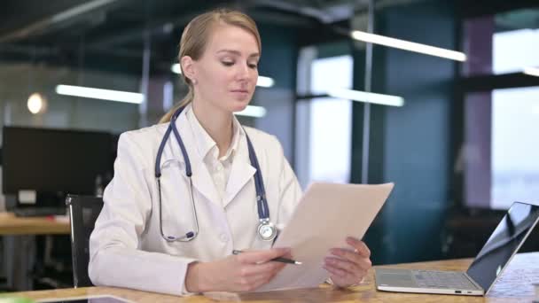 Весела молода жінка лікар дає документи клієнту — стокове відео
