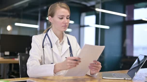 Laboriosa giovane medico femminile lettura documenti in ufficio — Video Stock