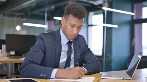 Poważny młody biznesmen robi papierkową robotę w biurze — Wideo stockowe