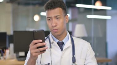 Ofiste akıllı telefon kullanan genç doktorun portresi