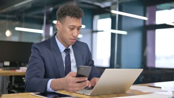 Veselý mladý podnikatel používající chytrý telefon v kanceláři — Stock video