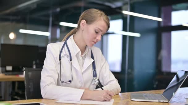 Enfocado joven médico haciendo papeleo en la oficina moderna — Vídeos de Stock