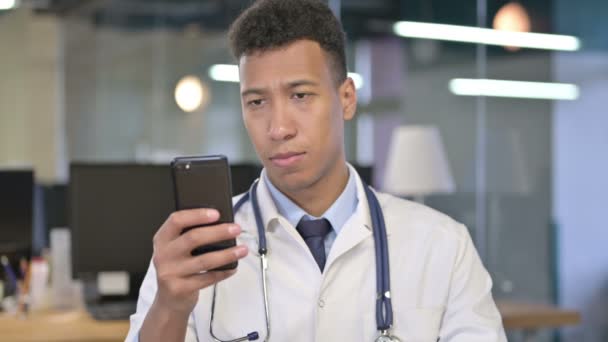 Портрет молодого врача с помощью смартфона в офисе — стоковое видео