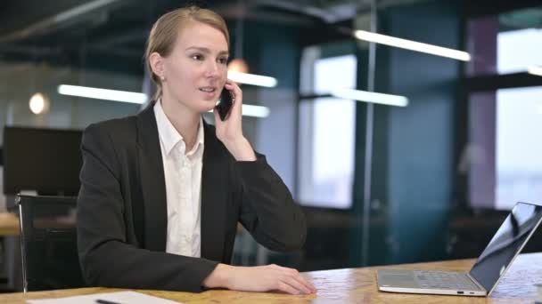 Feliz joven empresaria hablando en Smartphone en la oficina — Vídeos de Stock