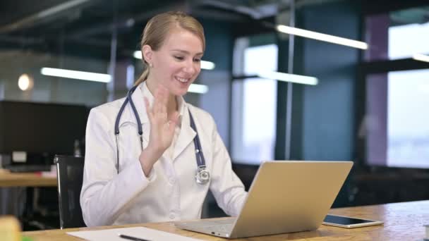 陽気若い女性医師は、ラップトップ上でビデオチャットを行う — ストック動画