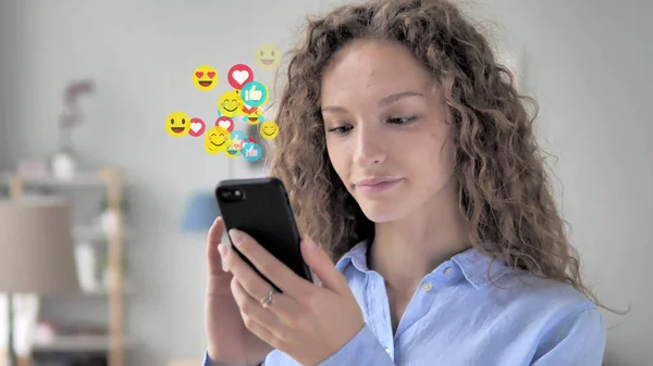 Młoda kobieta za pomocą smartfona, Emoji i lubi od zwolenników — Zdjęcie stockowe