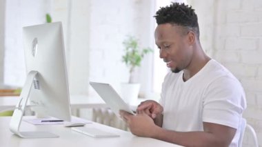 Ofiste Tablet kullanan sıkı çalışan Afrikalı Adam