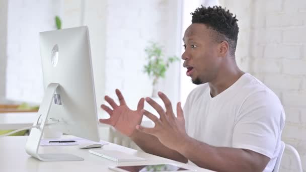 Impresionado hombre africano casual reaccionando al fracaso en el escritorio — Vídeos de Stock