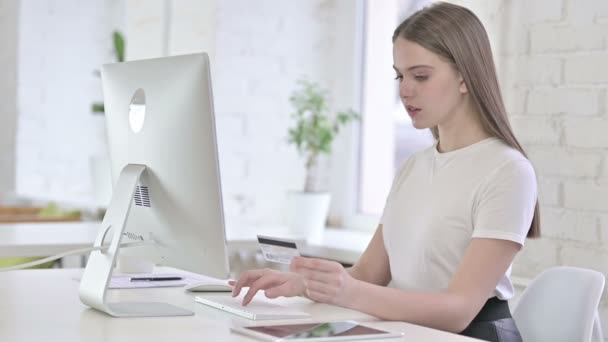 Молодая женщина празднует успех онлайн-платежей на рабочем столе — стоковое видео