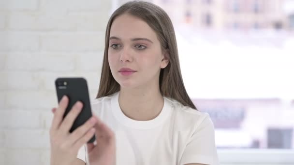 Porträt einer fröhlichen jungen Frau, die mit dem Smartphone spricht — Stockvideo