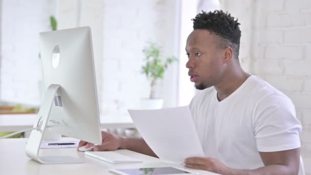 Homem Africano Casual fazendo Papelada com Desktop no Office — Vídeo de Stock