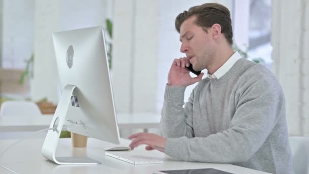 Joven hablando en Smartphone en la oficina — Vídeos de Stock