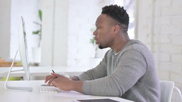 Homem Africano Jovem Profissional Pesquisando no Desktop no Escritório — Vídeo de Stock