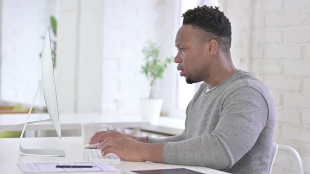 Casual Afrikaanse Man werken op Desktop en het hebben van hoofdpijn — Stockvideo