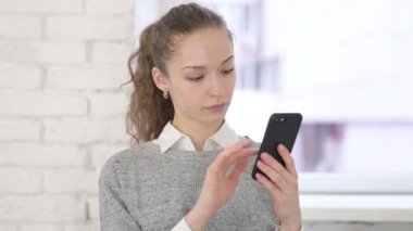 Smartphone kullanan Odaklanmış Genç Latin Kadın Portresi 