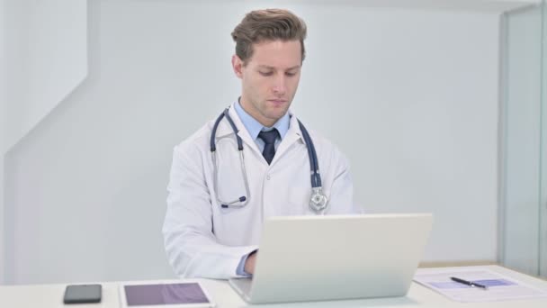Jovem médico focado trabalhando no laptop no escritório — Vídeo de Stock