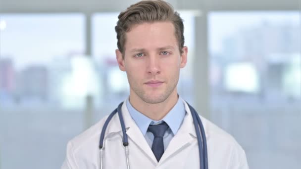 Retrato de un joven médico masculino mostrando pulgares hacia abajo en la oficina — Vídeo de stock