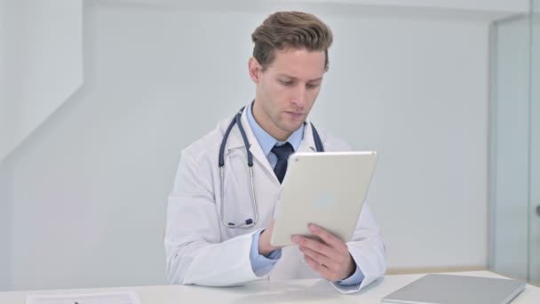 Travailler dur jeune médecin masculin en utilisant la tablette dans le bureau moderne — Video