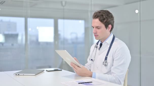 Focalisé jeune médecin masculin en utilisant la tablette dans le bureau moderne — Video