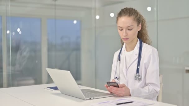 Szakmai Young Nő Doctor segítségével Smartphone az irodában — Stock videók