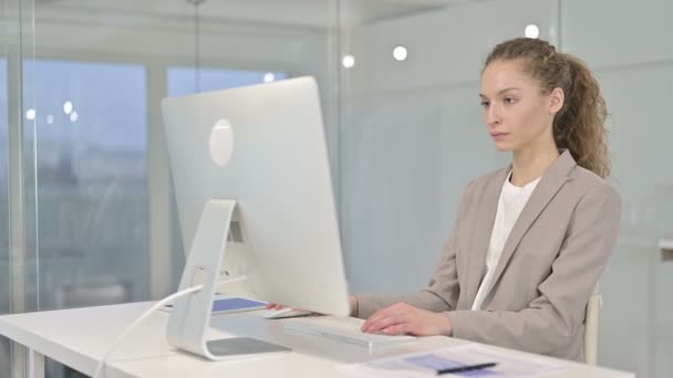 Серйозна молода бізнес-леді працює на робочому столі Top в офісі — стокове відео