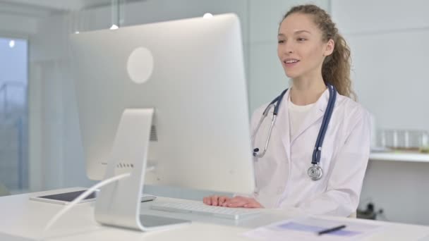 Porträtt av ung kvinnlig läkare gör videochatt på skrivbordet — Stockvideo