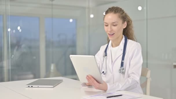 Doctora joven haciendo video chat en la tableta en la oficina — Vídeos de Stock