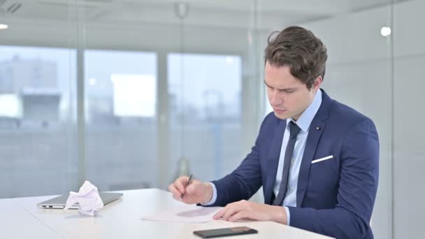 Enttäuschter Jungunternehmer versucht, auf Papier zu schreiben — Stockvideo