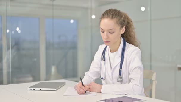 Jovem médico focado fazendo papelada no escritório moderno — Vídeo de Stock