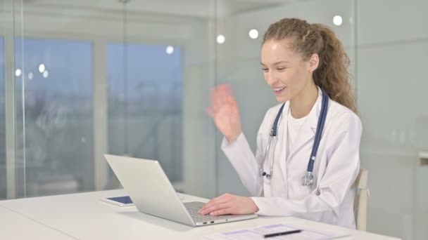 Alegre joven médico haciendo Video Chat en el ordenador portátil — Vídeos de Stock