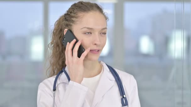 Портрет веселой молодой женщины-врача, разговаривающей по смартфону — стоковое видео