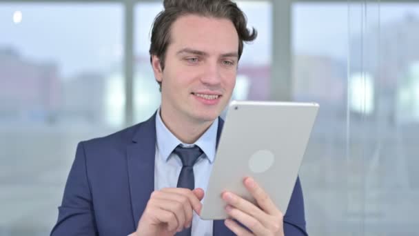 Portrait de joyeux jeune homme d'affaires faisant de la vidéo sur tablette — Video