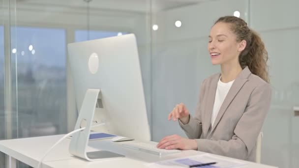 机の上でビデオチャットをする陽気な若いビジネスマンの女性 — ストック動画