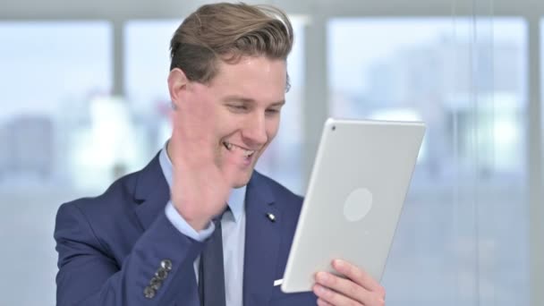 Portrait d'un jeune homme d'affaires attrayant faisant du chat vidéo sur tablette — Video